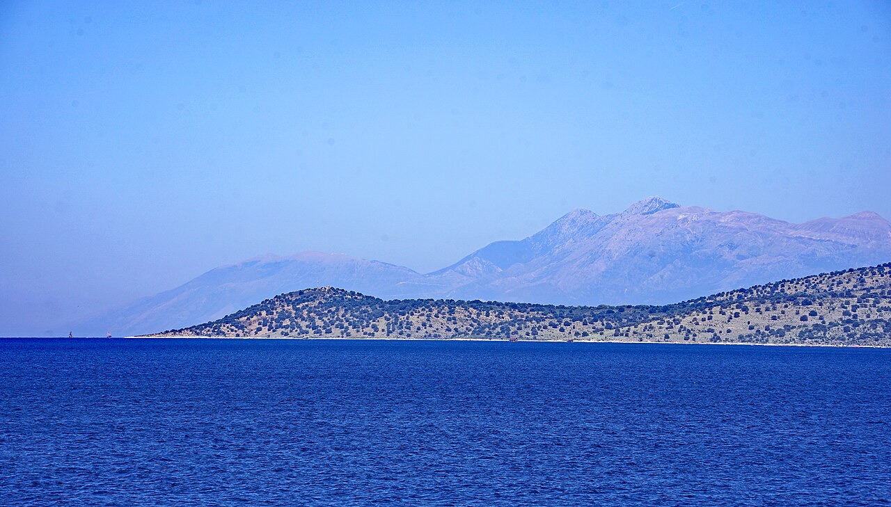 Qefali Cape (Kepi i Qefalit), West of Sarandë, Albania, with its lighthouse – in the background Maja e Çikës and Llogara Pass, some boats off the cape