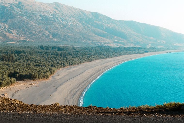Borsh Beach: a long pebble shore below olive groves and mountains