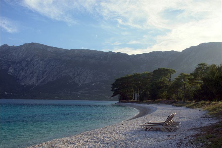 Drymades Beach: white pebbles with pines behind