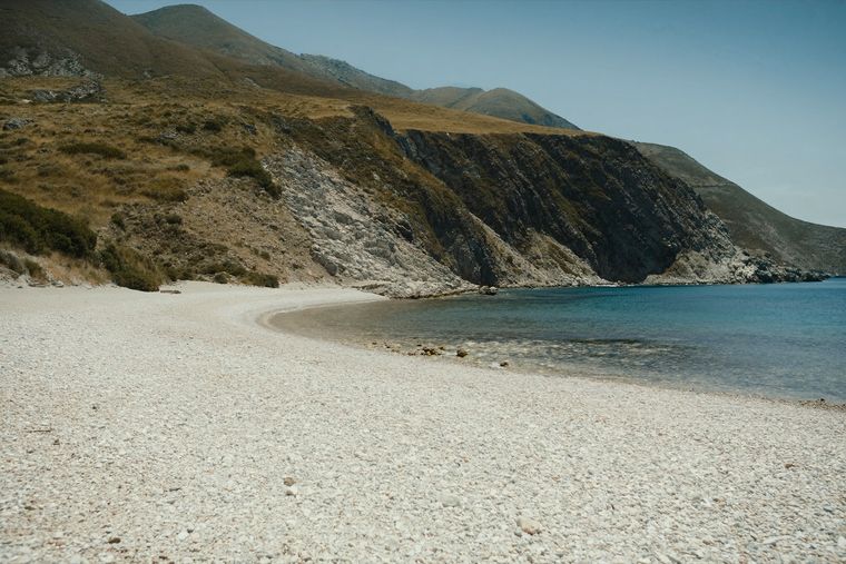 Krorëz Beach: a wide white pebble beach in a quiet cove