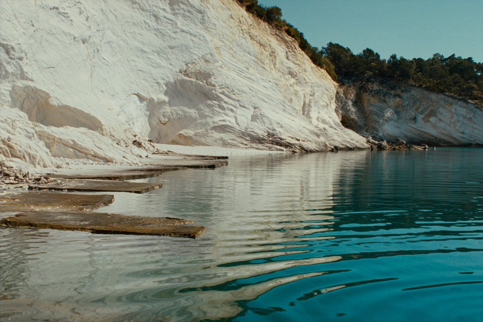 Mirror Beach: still water below a white limestone cliff
