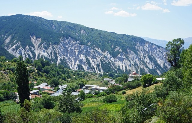 The village Radomirë in Dibër in Northern Albania with mountain Majë e Vleshës in the background