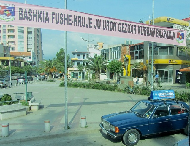 Bush Square in Fushë-Krujë, Albania seen through a bus window