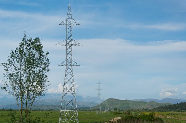 A high-voltage transmission tower in the Albanian landscape