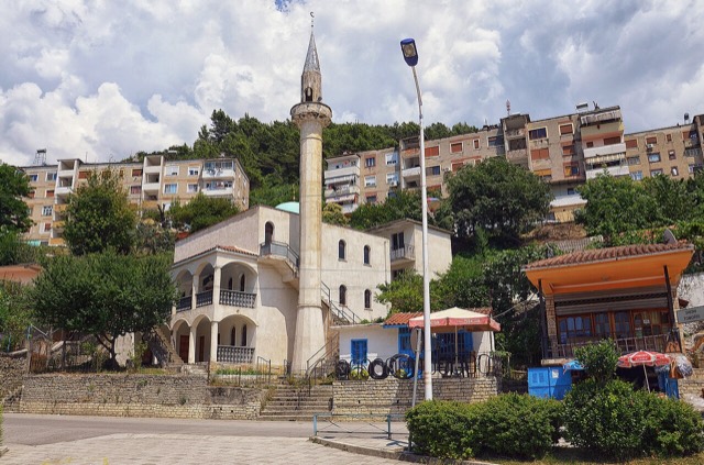 Poliçan, Albania – Residential houses from the Communist era with the mosque in the middle